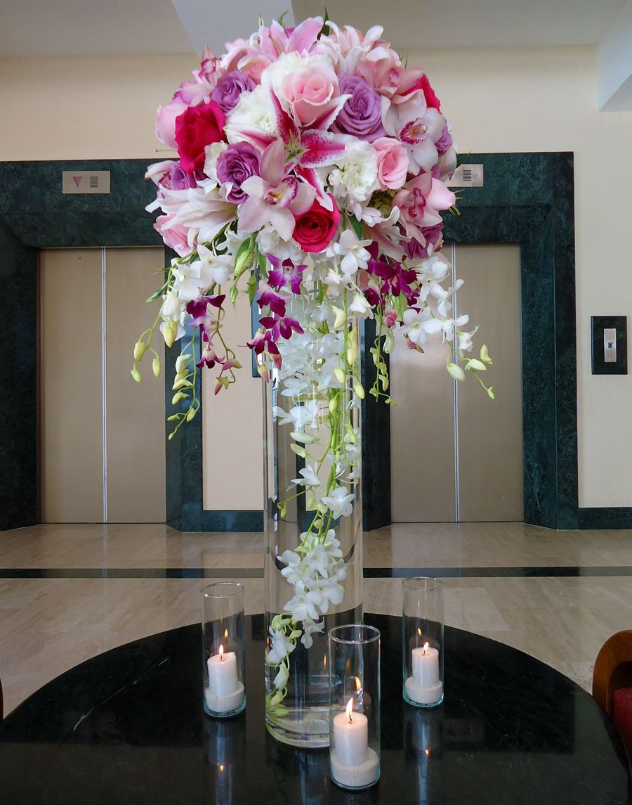 Extra Large Round Vase Of Tall Centerpiece 31 Height Vase with A White Dendrobium Large with Tall Centerpiece 31 Height Vase with A White Dendrobium Large Strand Submerged Lilac Pink Fuchsia Roses Stargazer Lily and Fuchsia White Hanging